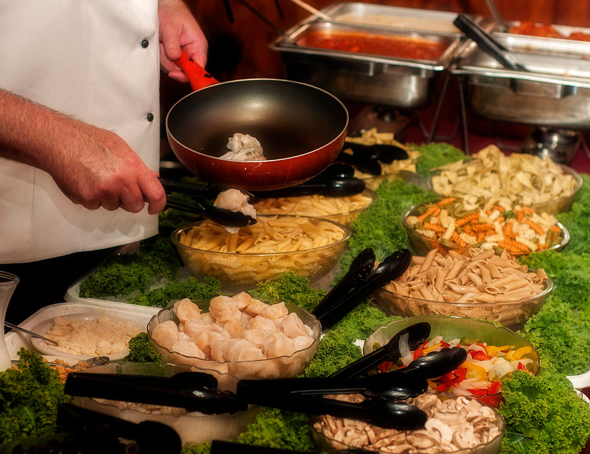 A man cooks delicious food at a catered event.